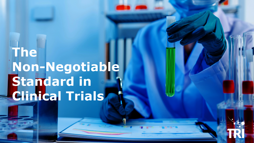 Laboratory professional holding a test tube above clinical data reports, surrounded by sample vials, with the title “The Non-Negotiable Standard in Clinical Trials” and the TRI logo.